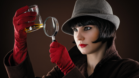 Female detective examining a glass.