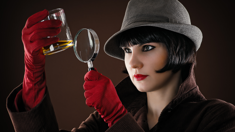 Female detective holding magnifying glass.
